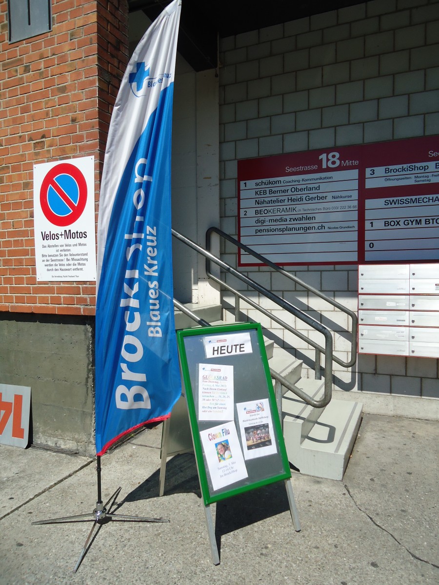 (138'612) - 5 Jahre BrockiShop Thun: Fahne und Hinweistafel mit Parkverbot beim Eingang am 4. Mai 2012