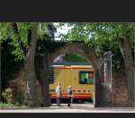 . Hinter dem Tor - Auf der anderen Seite des Tores quert ein Stadtbahnzug der Albtalbahn den dortigen Bahn�bergang, Ettlingen am 19.04.2009 (Matthias)