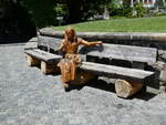 denkmaeler/781931/237297---das-vogel-lisi-aus-holz (237'297) - Das Vogel-Lisi aus Holz sitzt am 19. Juni 2022 auf dem Bank vor der Kirche in Adelboden