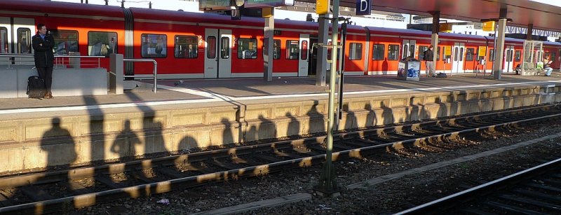 Wartende Reisende auf dem Bahnhof. Die Menschen auf dem Bahnsteig geben als Schatten ein merkw�rdiges Bild ab. Anonym, gesichtslos, nur ein Schatten in der Menge ...